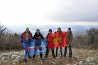 Участники похода с флагами на вершине горы