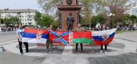Соратники с флагами у памятника в Симферополе