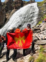 Дмитрий и его друг с флагом Движения у водопада