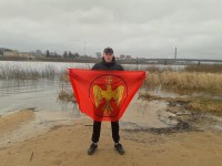 Соратник с флагом на фоне города Даугавпилс